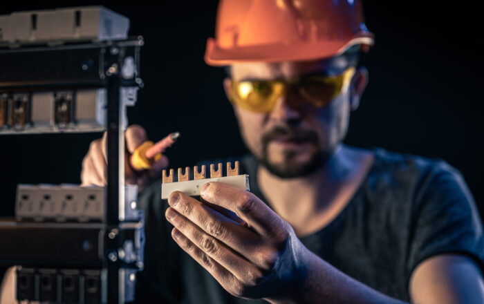 male-electrician-works-switchboard-with-electrical-connecting-cable